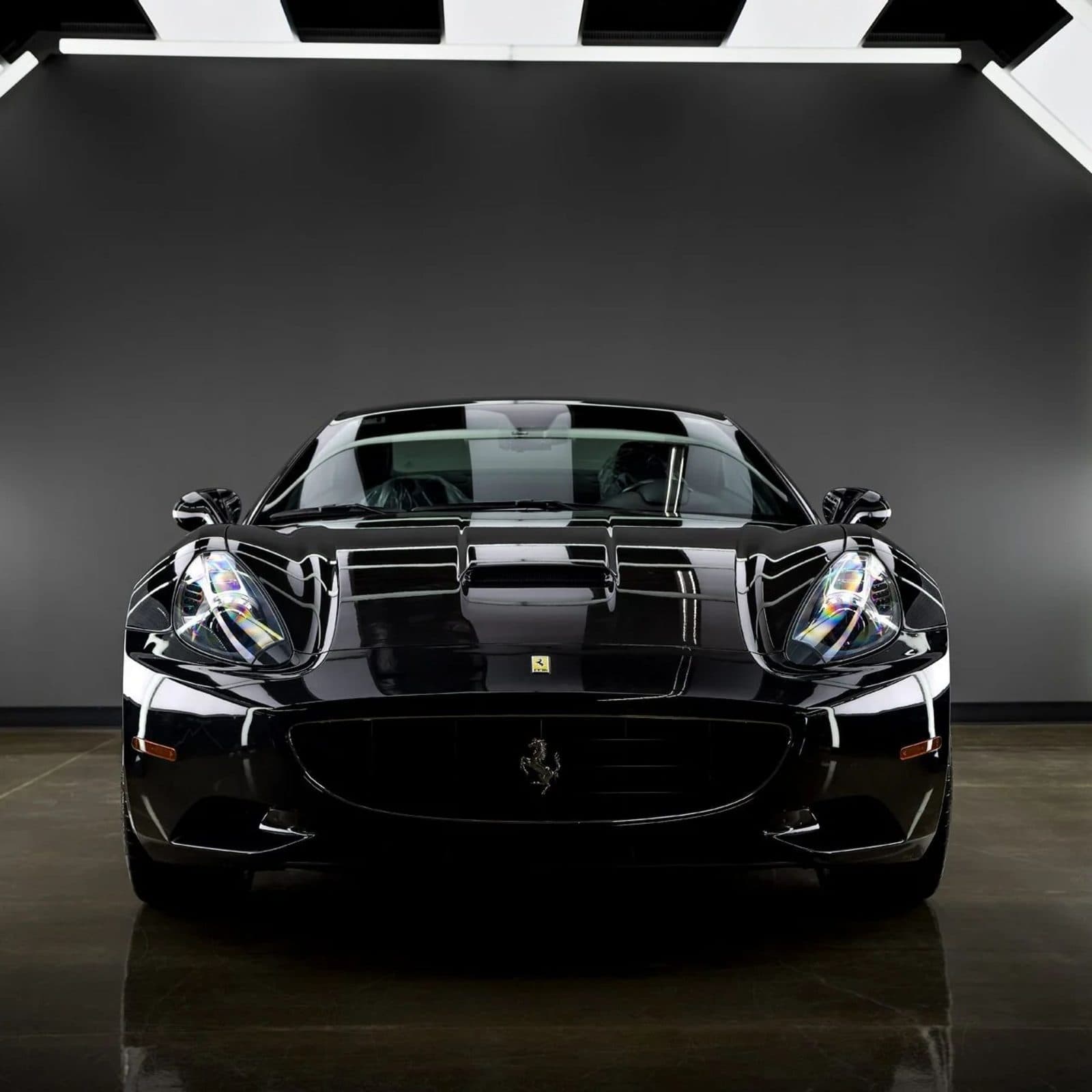 Front end of a black sports car finished under studio light