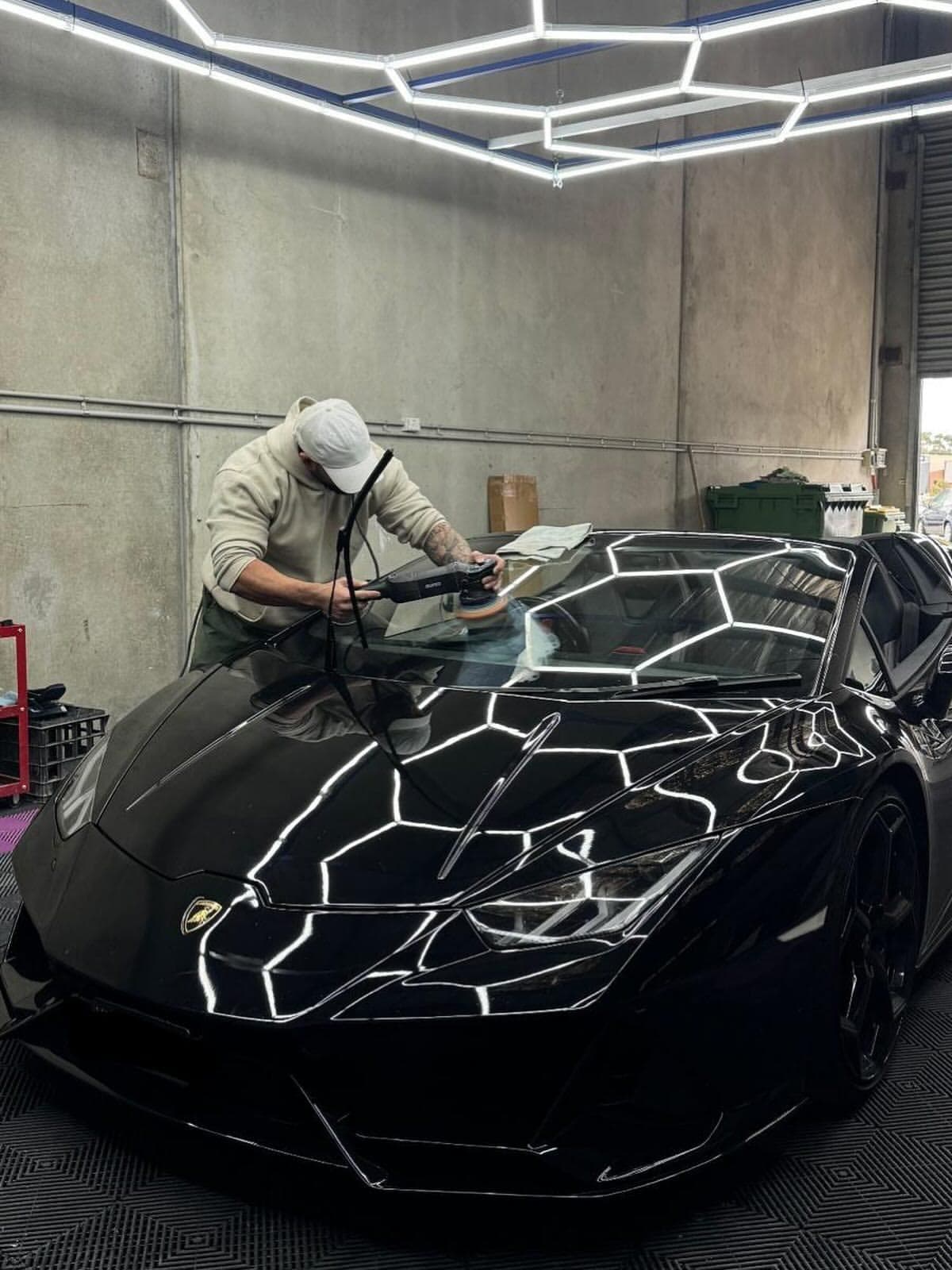 Jesse machine polishing the bonnet of a black Lamborghini Huracan at Detail 2 Drive